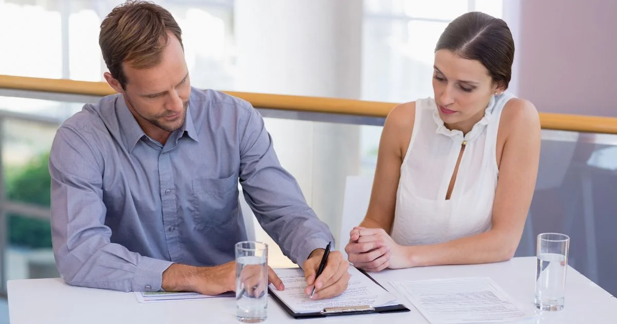 Couple signing legal agreement with advisor