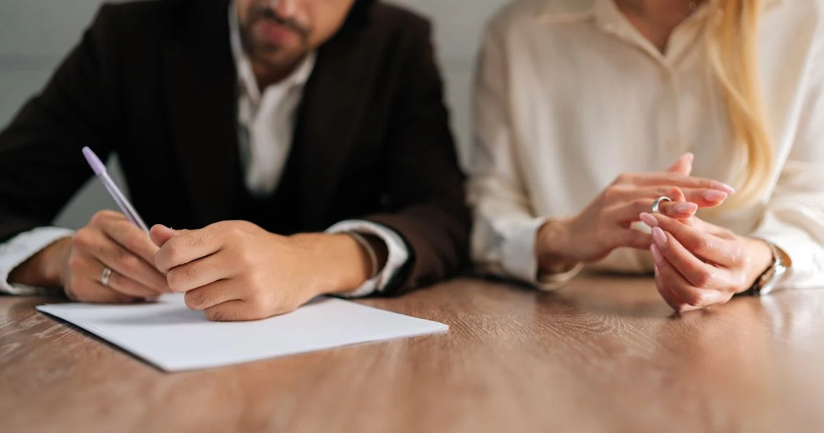 Couple signing separation agreement at table